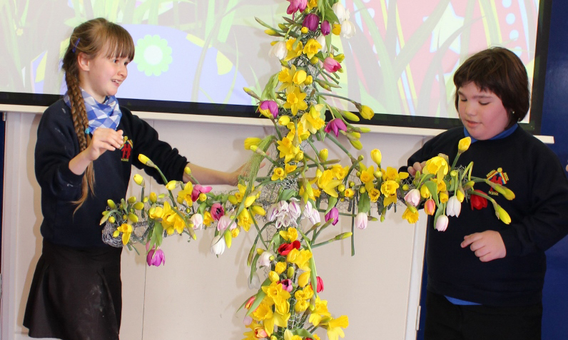 CHILDREN DONATE FLORAL EASTER CROSS TO HOSPICE