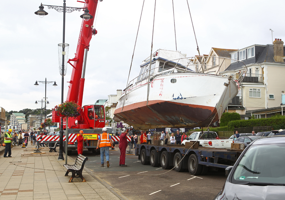 WRECKED BOAT LIFTED FROM BEACH