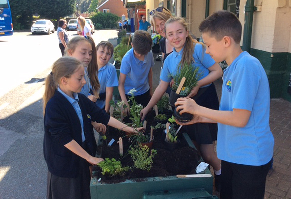 CHILDREN PLANT NEW FLOWERS AT SANDOWN STATION
