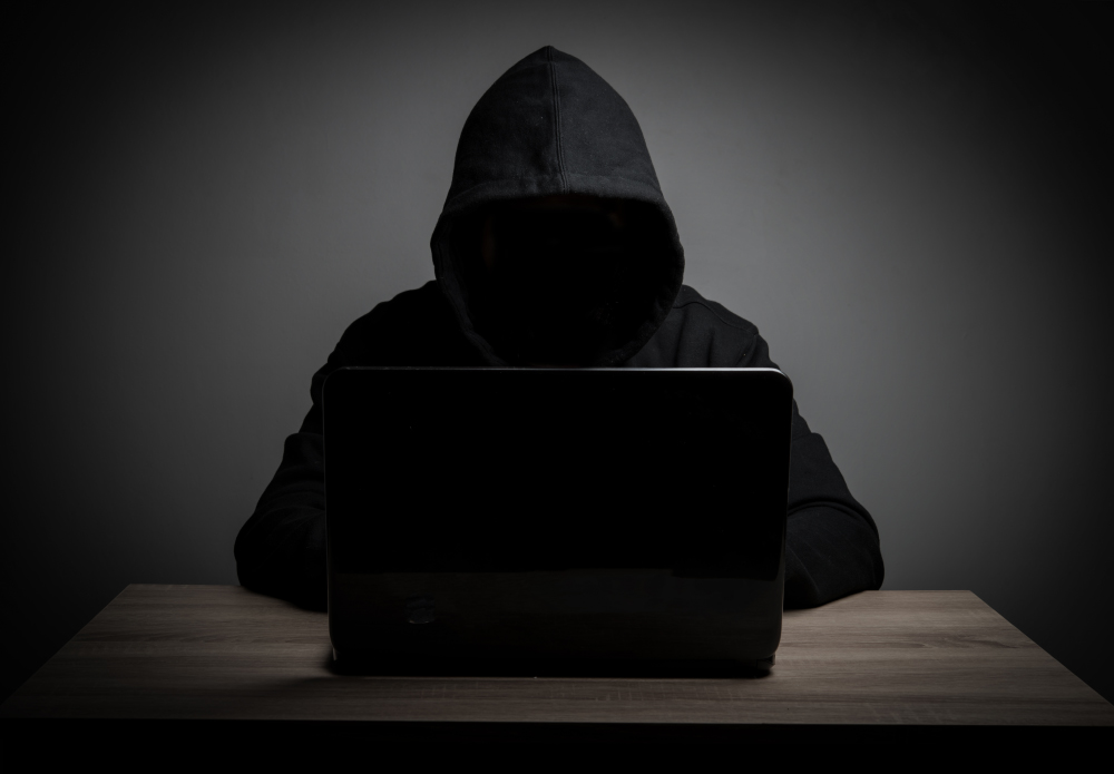 Hacker Work Front Of His Laptop Computer With Dark Face.