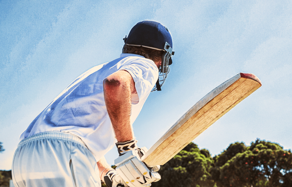 Side View Of Cricket Player Batting While Playing On Field Against Clear Sky