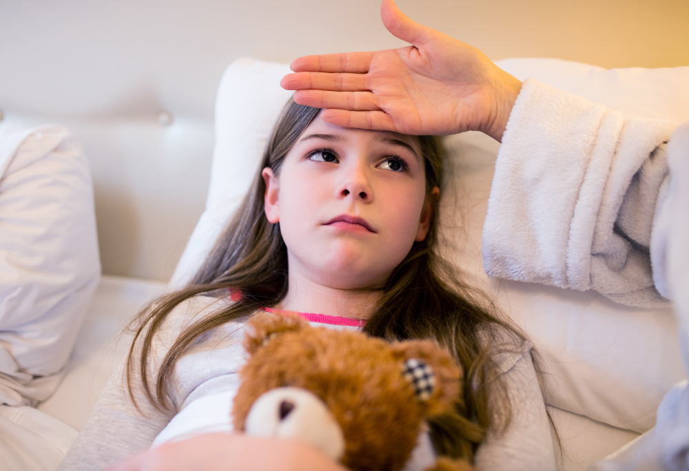 Mother Checking Fever Of Her Daughter In Bedroom