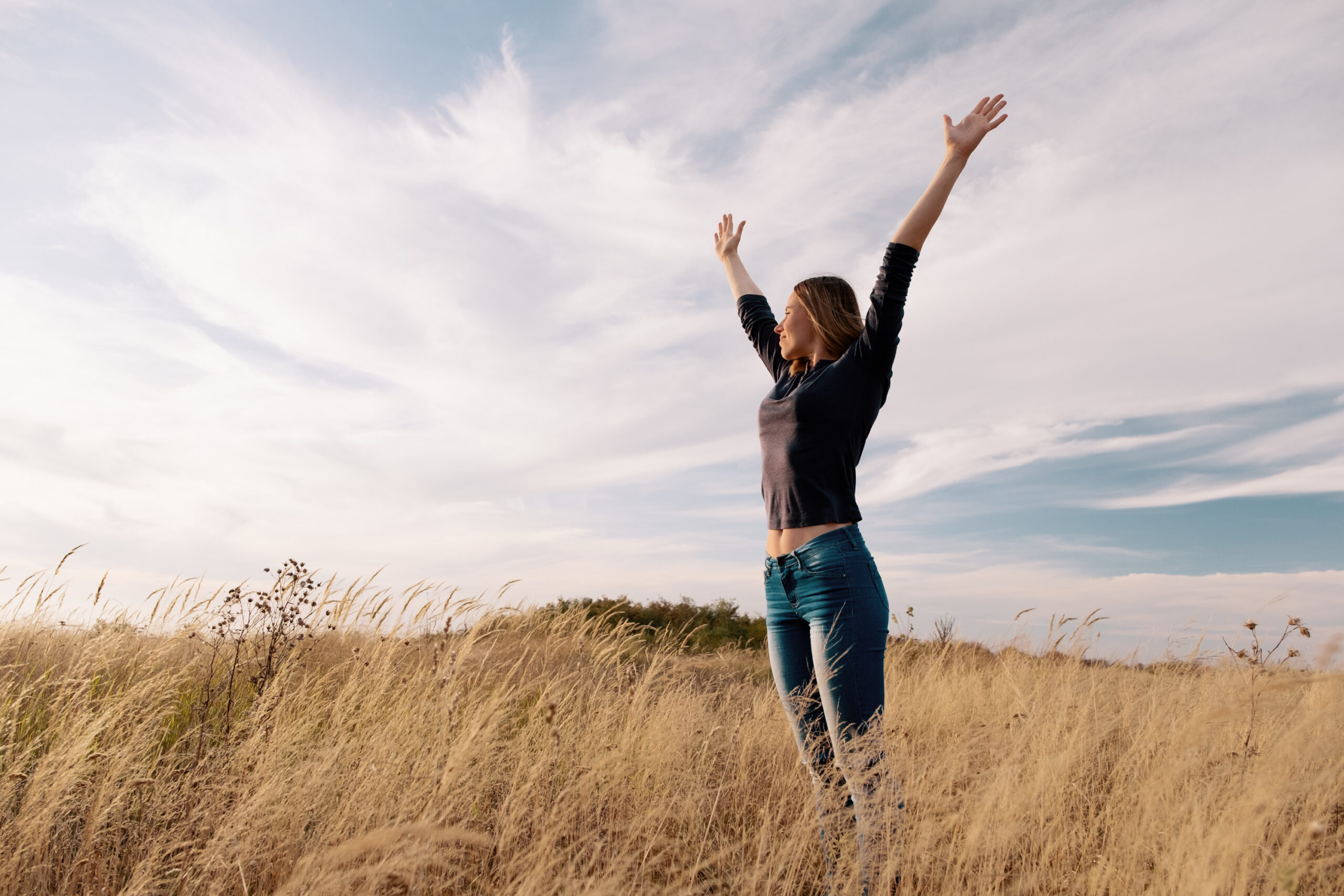 Young Happy Woman In A Golden Field On Sunset.