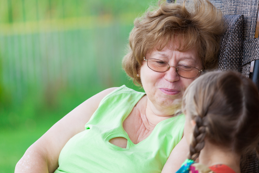 A Woman Talks To A Girl Sitting On A Sun Lounger Near The House