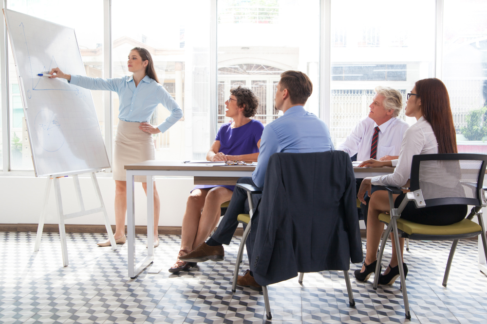 Female Business Coach Explaining Graph At Meeting
