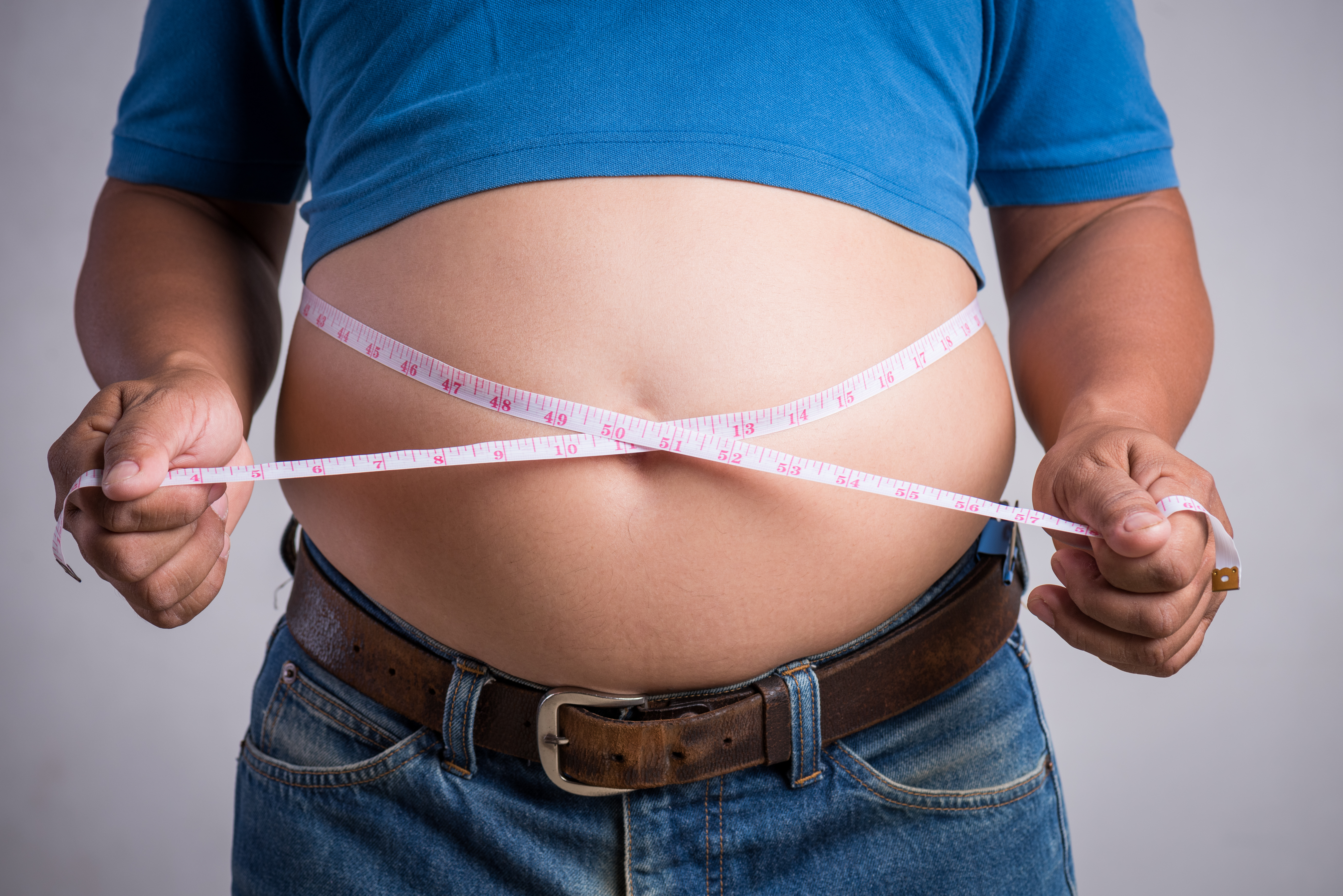 Overweight Or Fat Adult Man In Very Tight Jeans With Measuring T