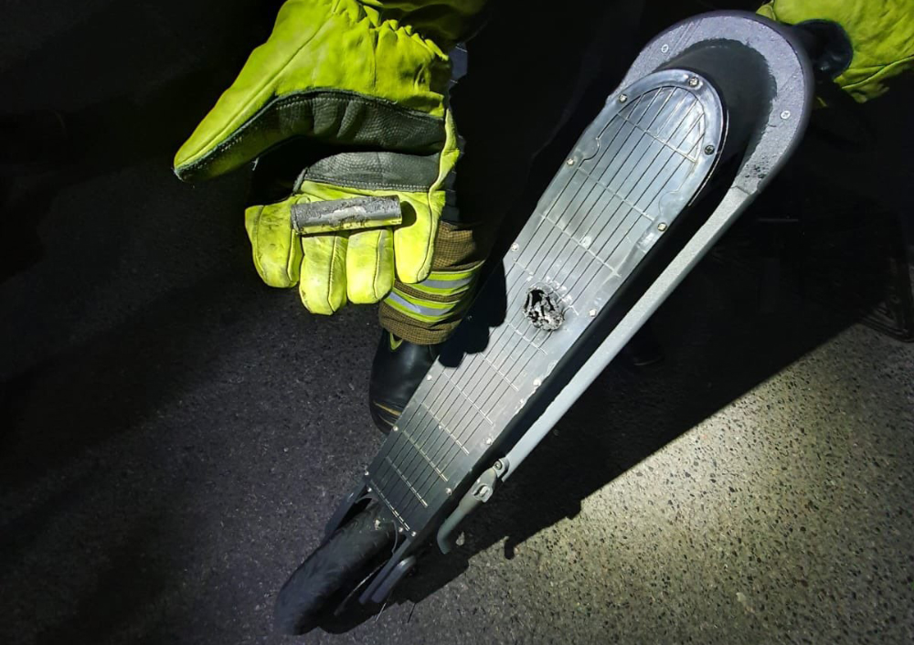 Firefighter Holding Escooter Battery Which Caused Fire