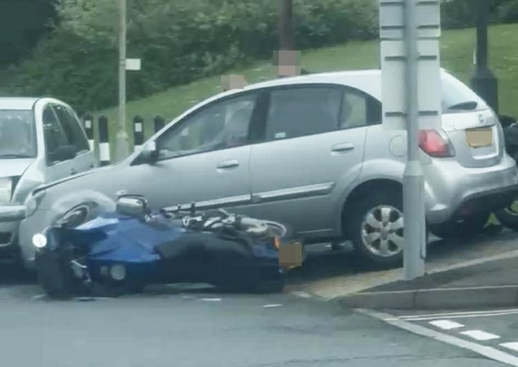 KIA MOUNTS PAVEMENT AND HITS MOTORCYCLE AND CAR AT HOSPITAL CAR PARK