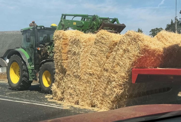 TRACTOR SPILLS LOAD OF HAY ON DOWNS ROAD CAUSING TRAFFIC DELAYS