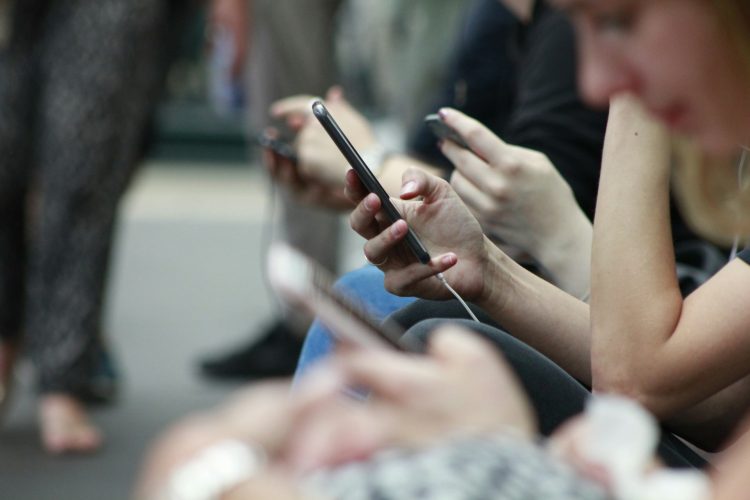 Person holding a phone showing social media apps